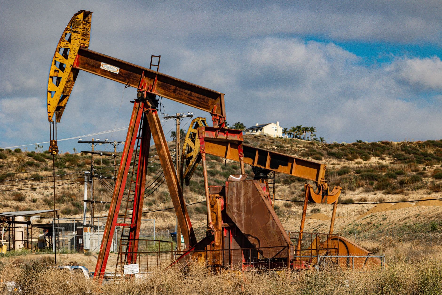 Balancines petroleros, un barril sin marcas y pilas de monedas simbolizan el alza del crudo y de las ganancias en Estados Unidos.
