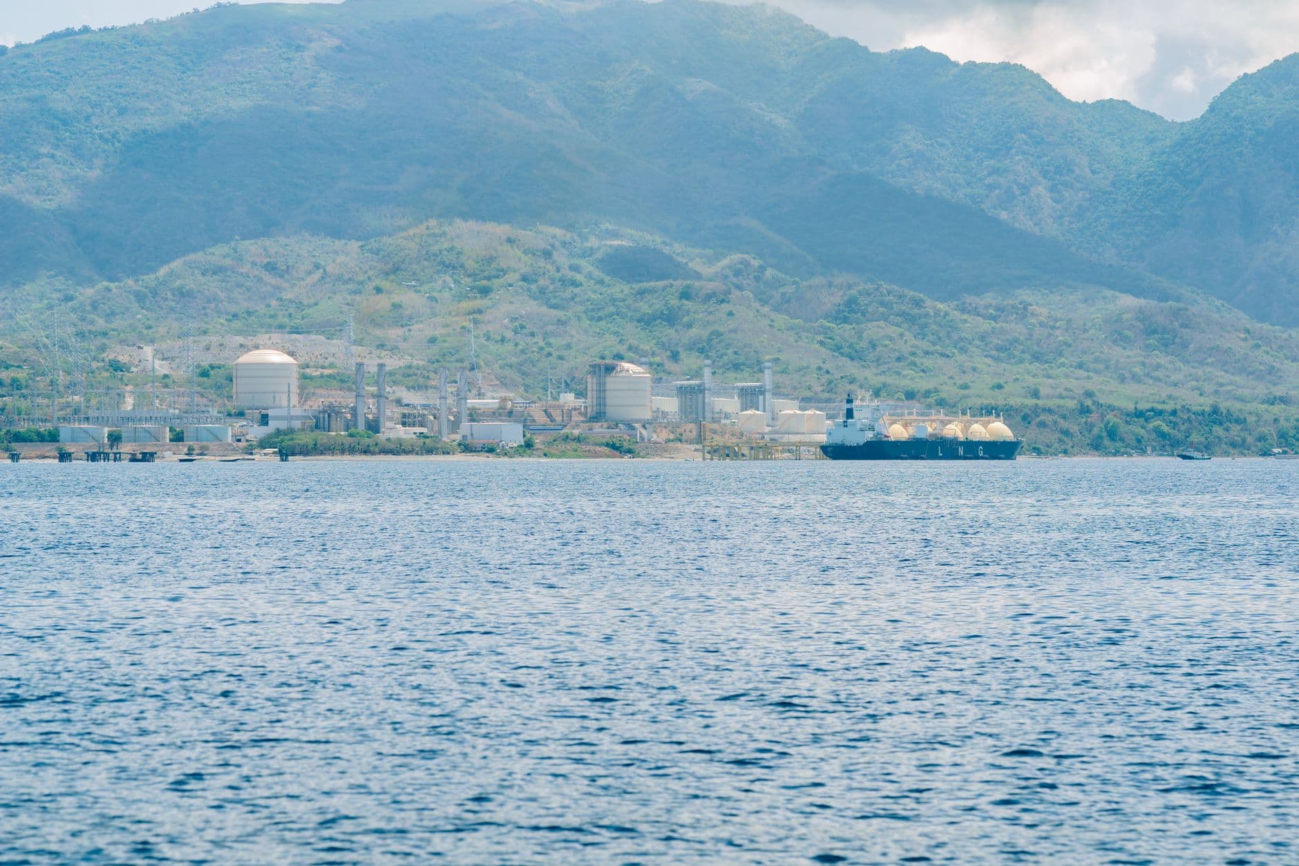 Planta costera de GNL con tanques y un buque metanero en la costa tropical de Sabah, Malasia.